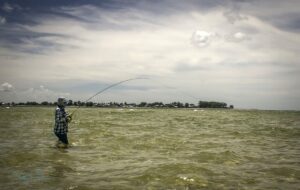 An angler casts a line into the water.